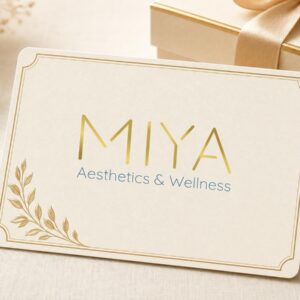 MIYA Aesthetics and Wellness gift card beside a wrapped gift box with a gold ribbon