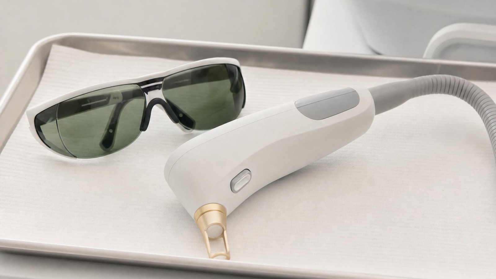 Laser handpiece and protective safety glasses arranged on a clinical tray